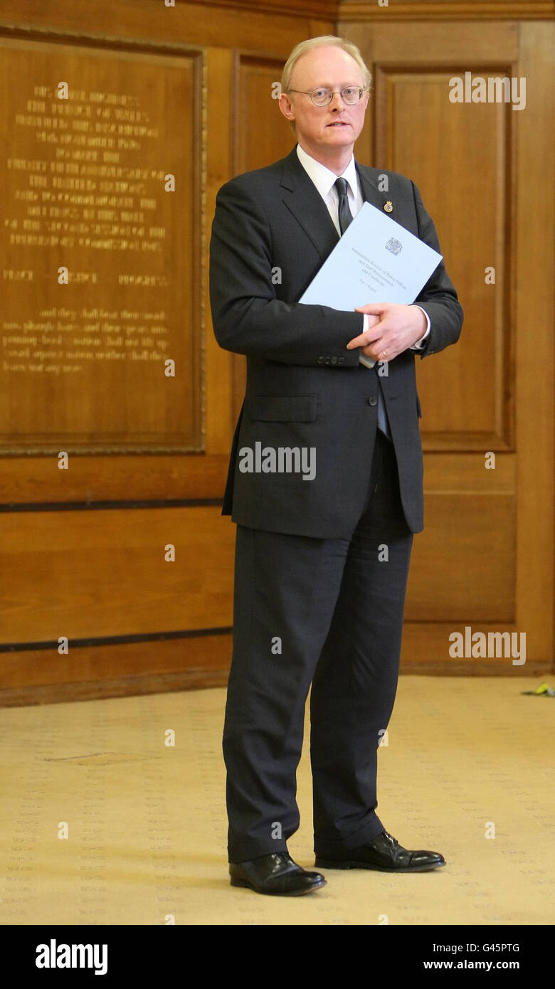 Former rail regulator Tom Winsor with a copy of his review into police pay and conditions, at
