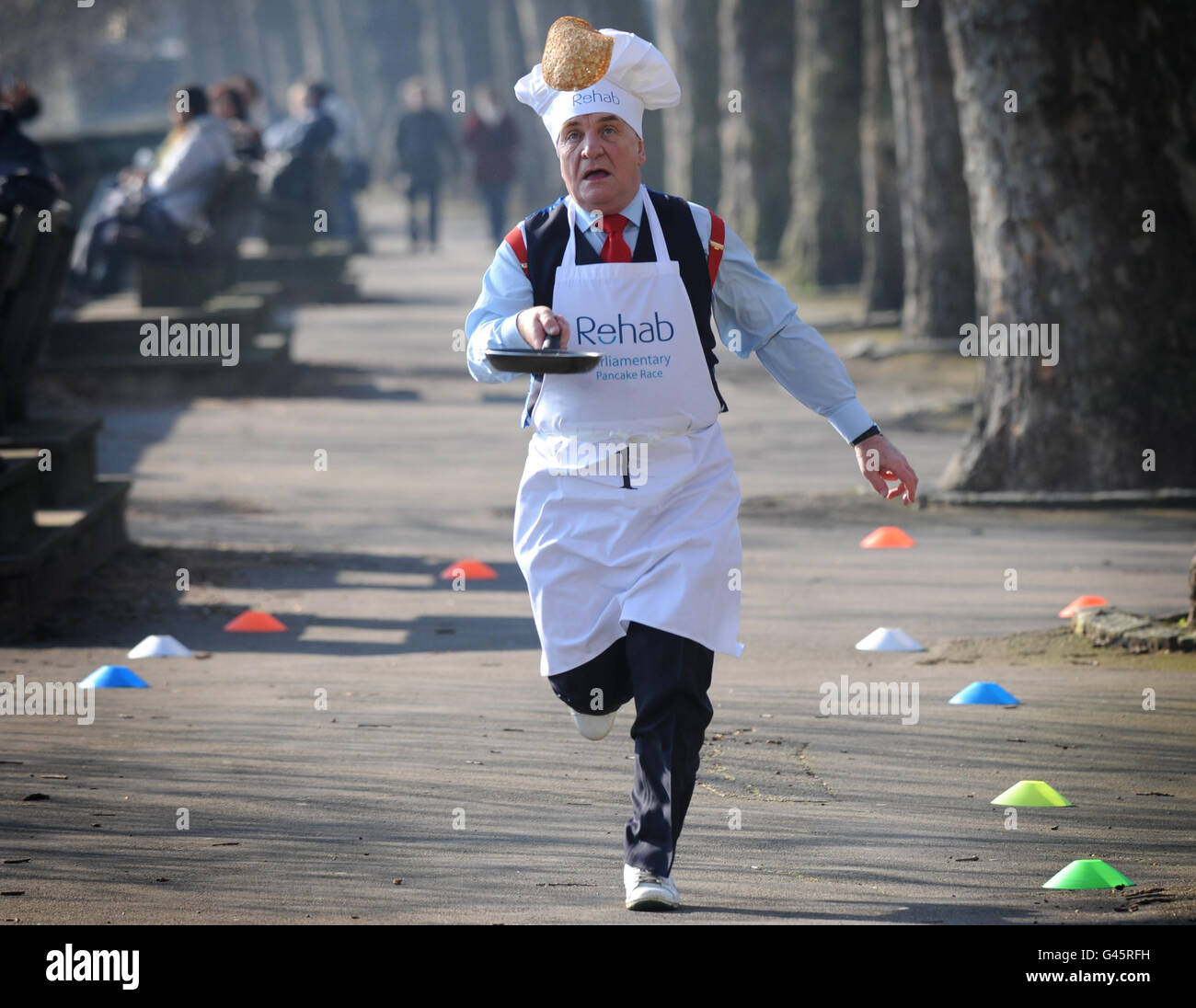 Labour MP Stephen Pound competes in the annual Rehab UK Parliamentary Pancake Race in Westminster, London, to help raise awareness for the charity - which helps people with diabilities. Stock Photo