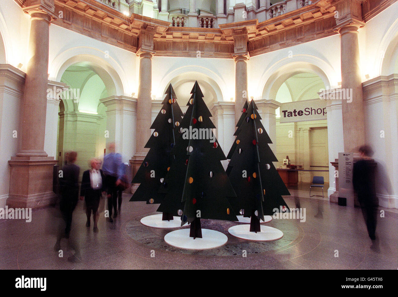 Members of the public view 'A Christmas Forest' designed by artist Julian Opie at the Tate Gallery in London today (Tue). The gallery has broken with tradition of having a single tree on display by showing the Xmas trees in the rotunda. Photo by Fiona Hanson/PA. Stock Photo