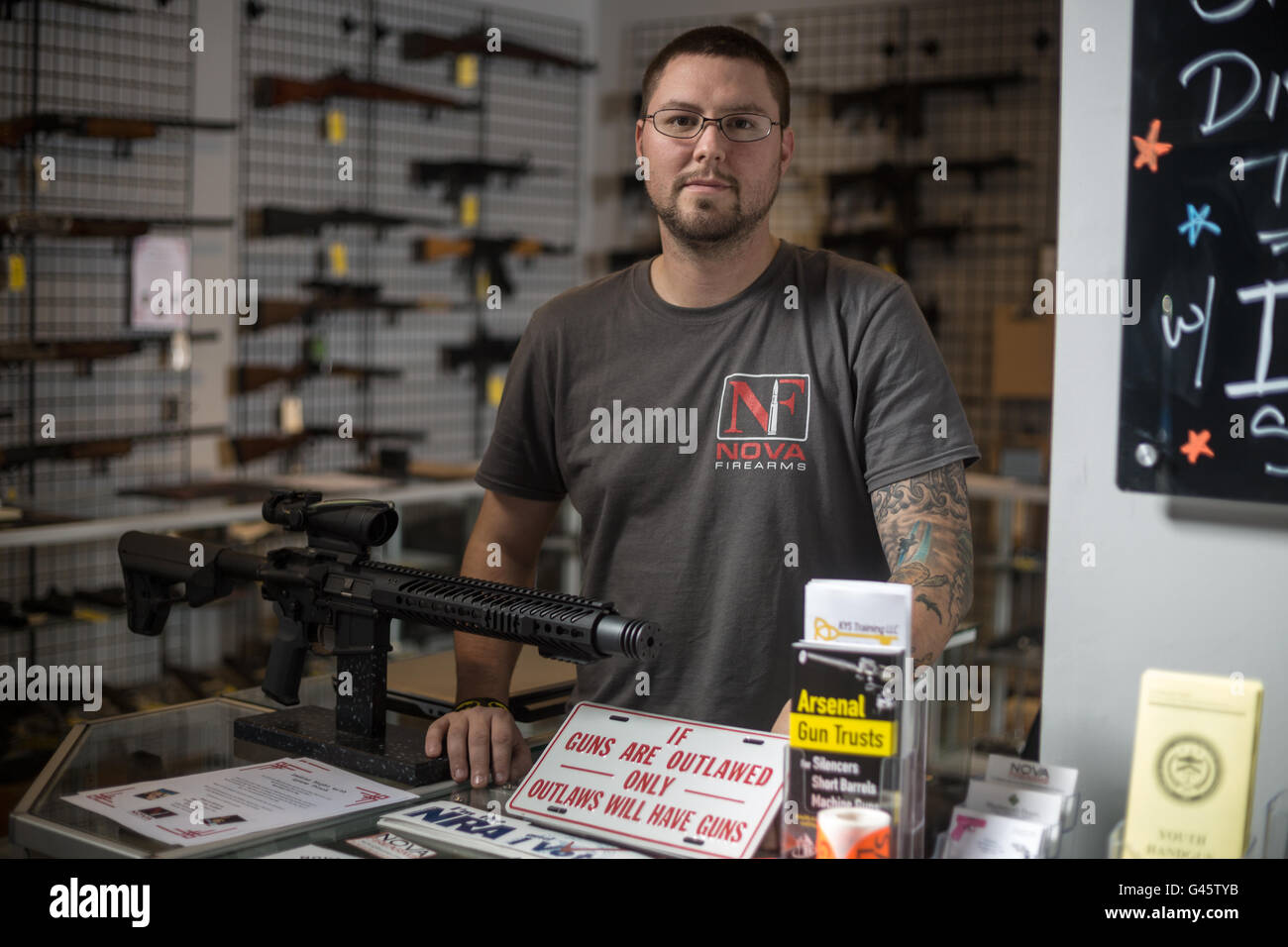 Owner of NOVA Firearms J.B. Gates behind a counter in his shop on November 4, 2015 in McLean Virginia. NOVA Firearms has had to  Stock Photo