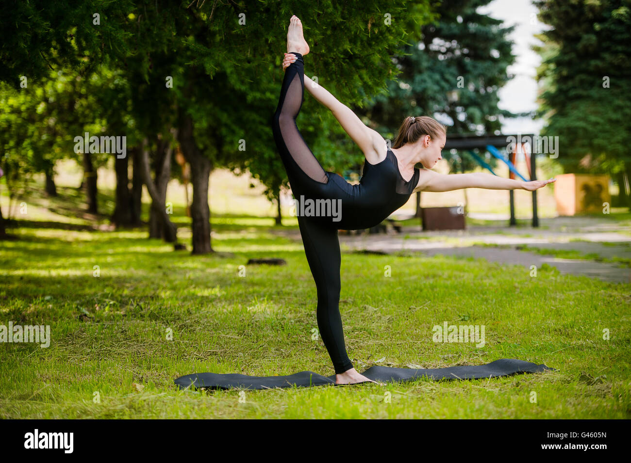 Balance exercise - young woman exercising in park Stock Photo - Alamy