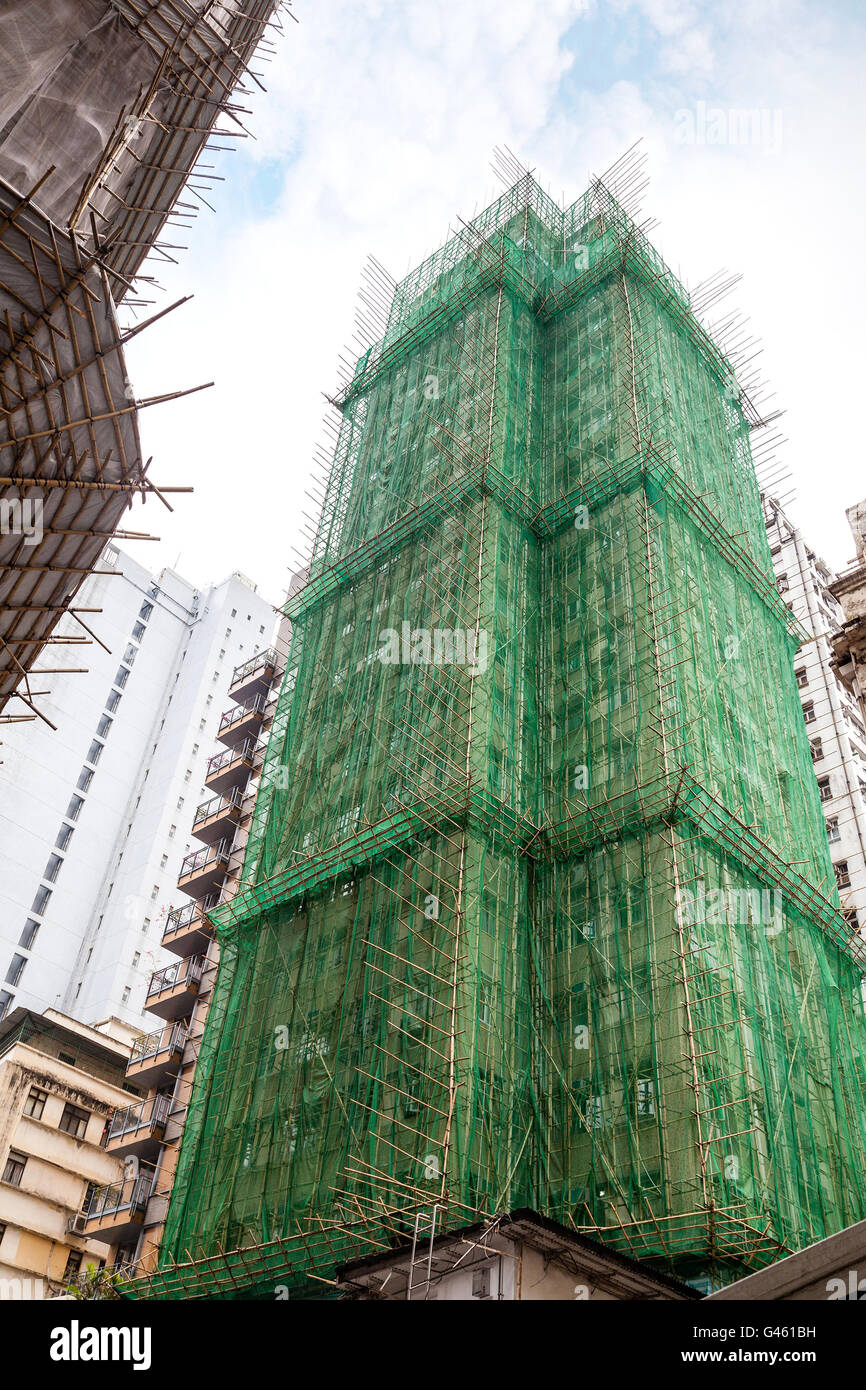Traditional bamboo scaffolding surrounds a building under construction in Hong Kong, China. Stock Photo