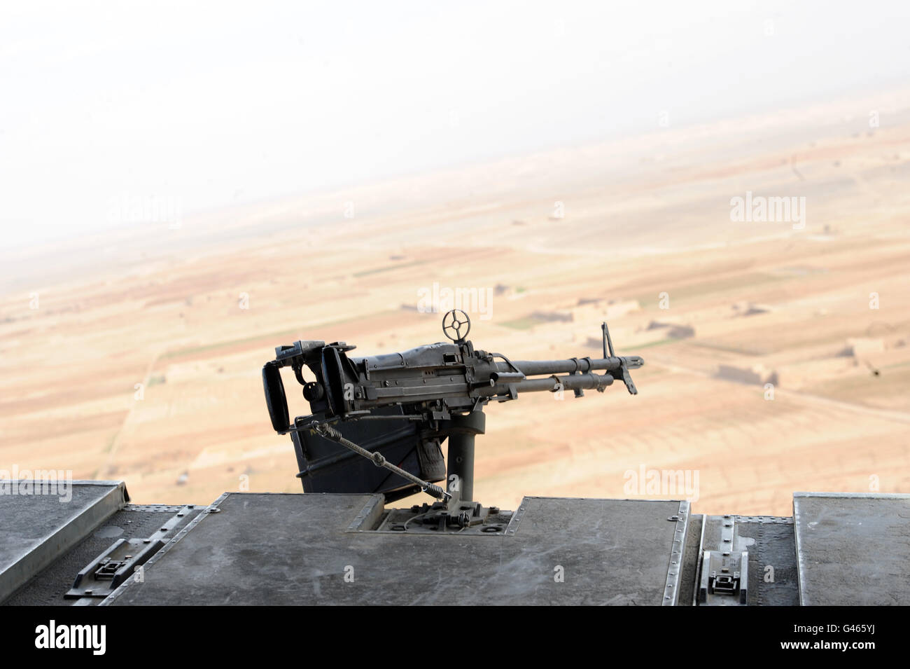 Chinook helicopter weaponry is seen before the Afghanistan landscape during flight Stock Photo