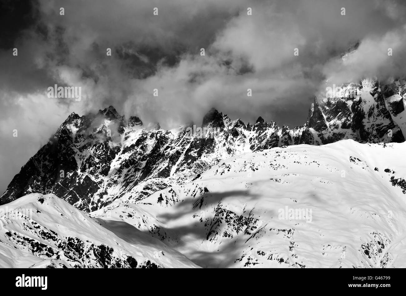 Black and white snowy rocks in haze at sunny day. Caucasus Mountains. Svaneti region of Georgia. Stock Photo