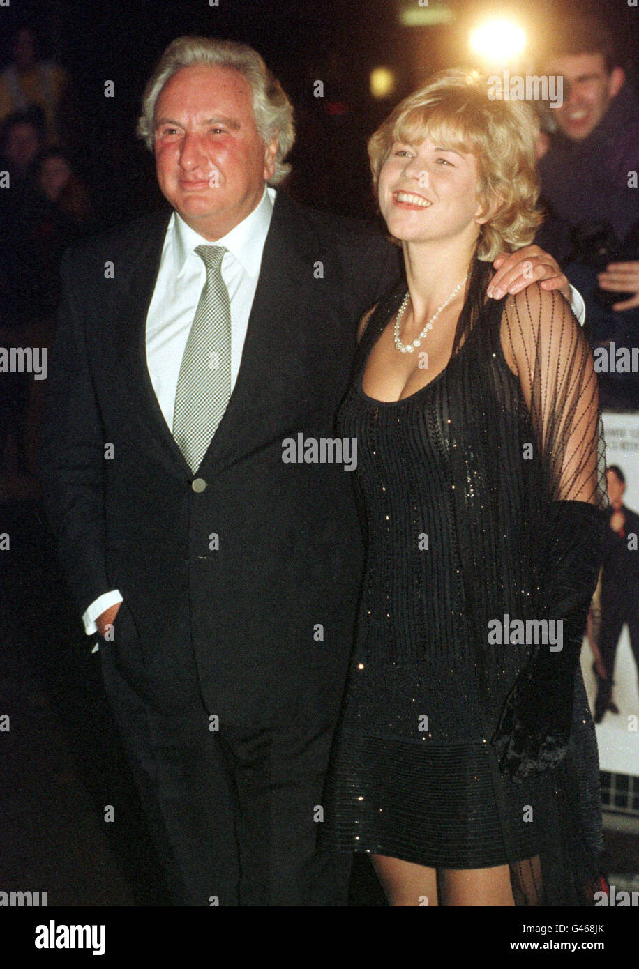 FILM DIRECTOR MICHAEL WINNER AND GIRLFRIEND VANESSA PERRY ARRIVES AT THE EMPIRE LEICESTER SQUARE FOR THE PREMIERE OF 'FIERCE CREATURES'. Stock Photo