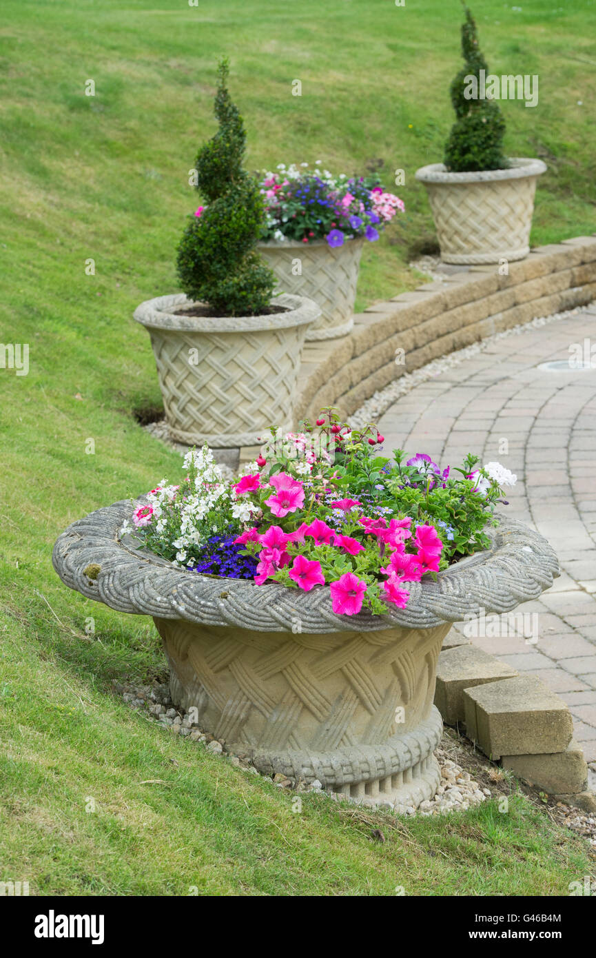 Flora stone urns in a cottage garden. Ashton Under Hill, Wychavon district, Worcestershire, England Stock Photo