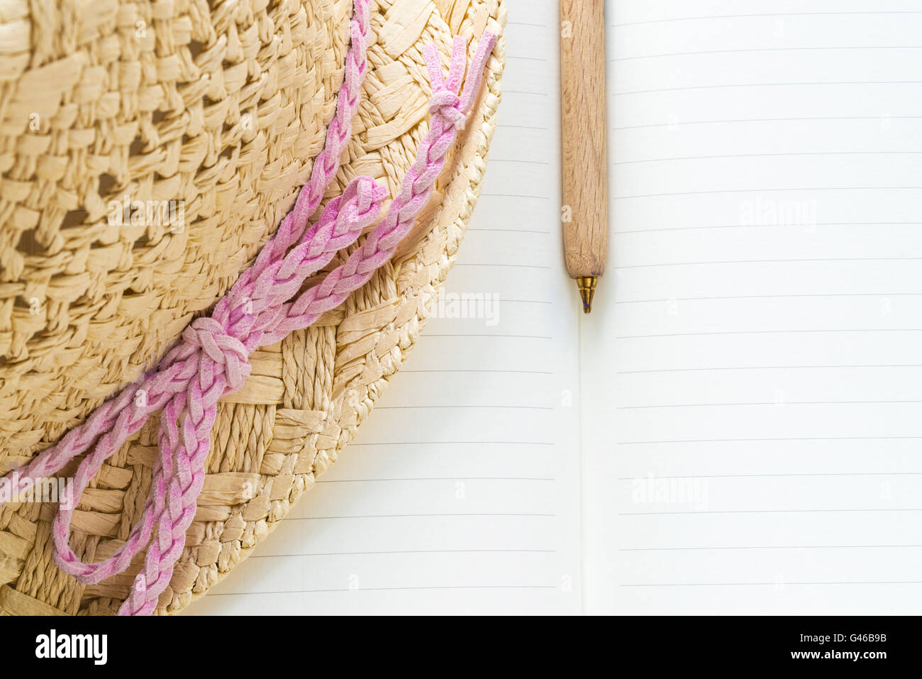 Closeup of a notebook, wooden pen and straw hat with a pink bow Stock ...