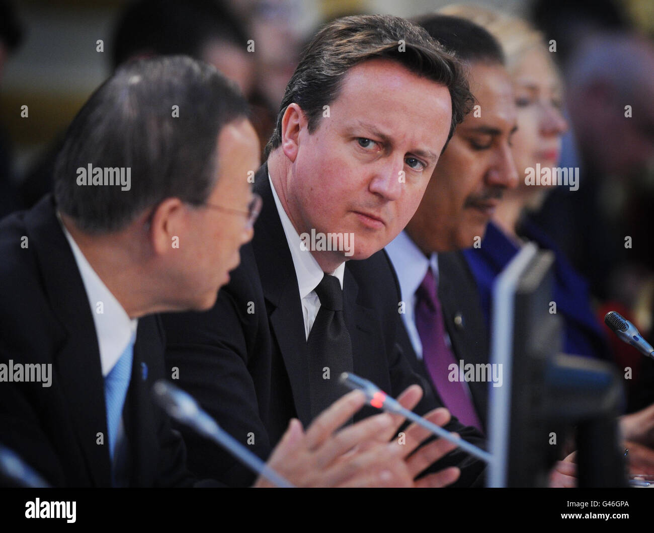 British Prime Minister David Cameron listens to UN Secretary General Ban Ki Moon speak at the opening of the Libyan Conference in London. Stock Photo