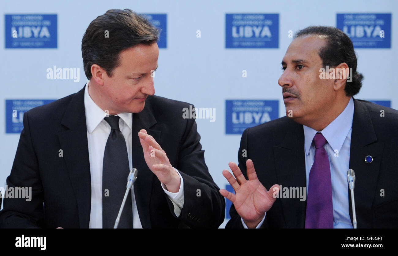 British Prime Minister David Cameron speaks to the Prime Minister and Minister of Foreign Affairs of Qatar His Excellency Sheikh Hamad Bin Jissim Bin Jabr Al Thani at the opening meeting of the Libya Conference in London. Stock Photo