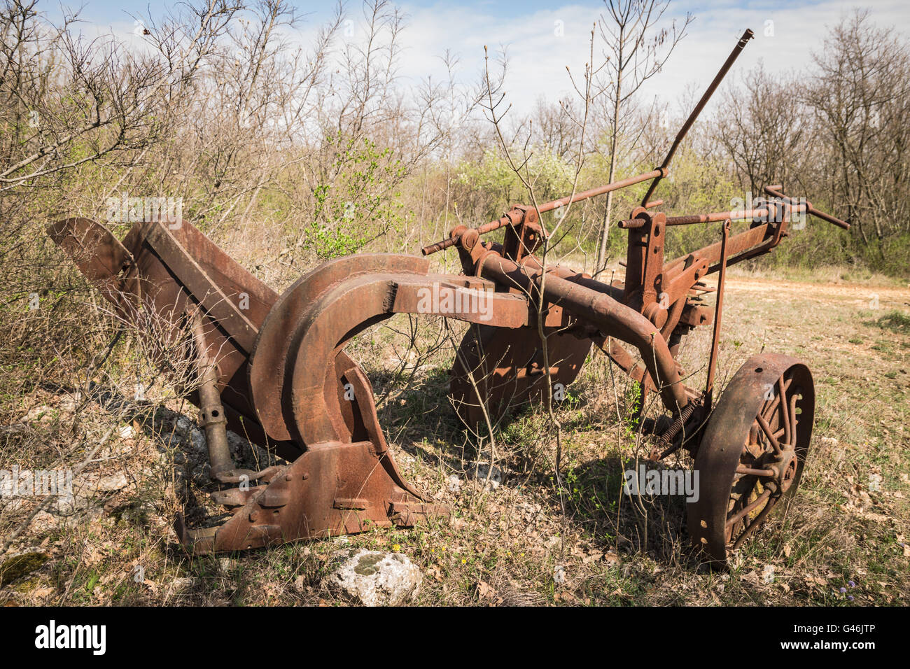 Old rusty iron plow abandoned in an overgrown field Stock Photo Alamy