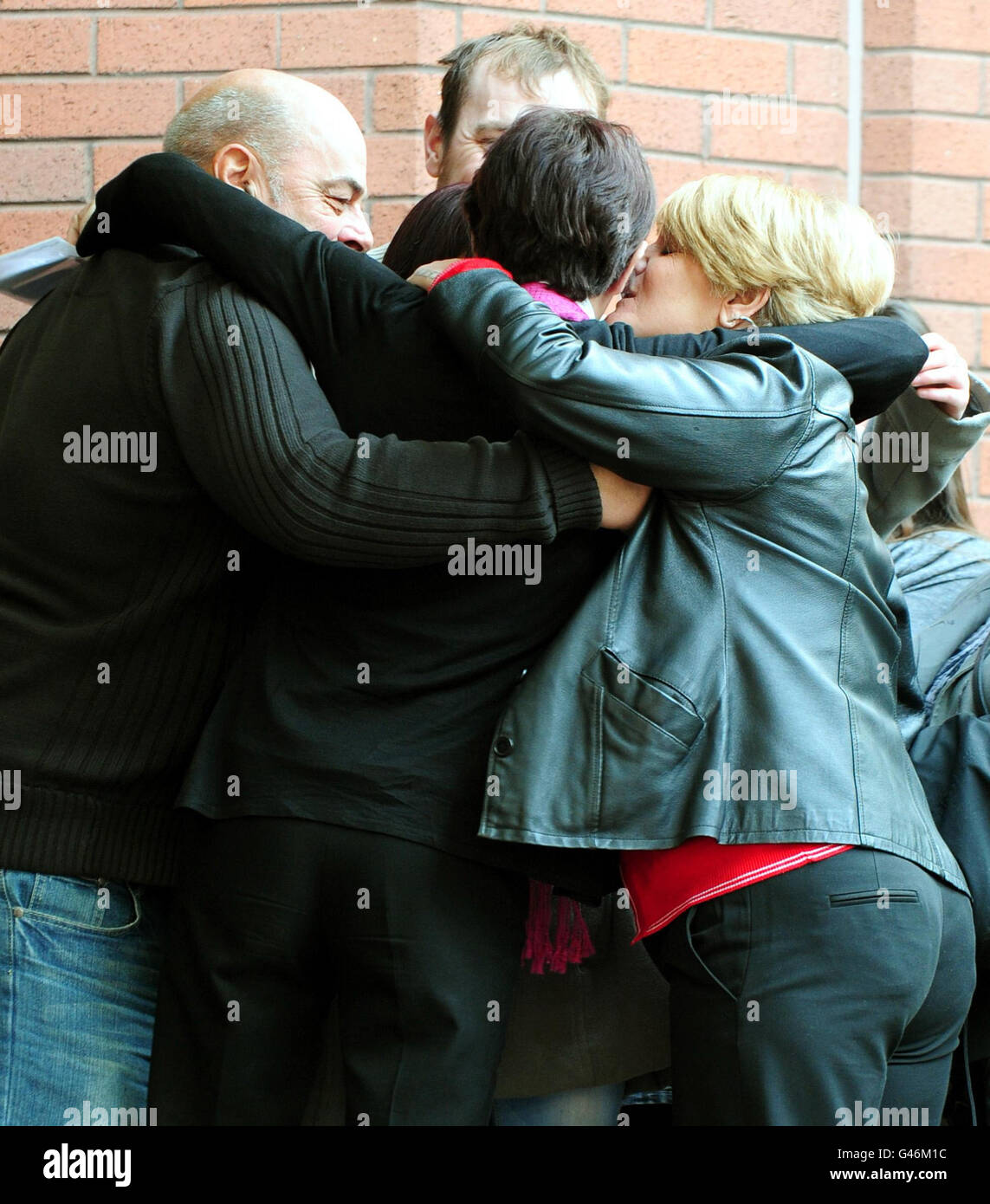 Kim Smith (centre, back to camera) is hugged by family outside Birmingham Crown Court, where Christopher Grady was convicted of murdering their five-year-old daughter Gabrielle after he drove his car into a freezing river with her on the front passenger seat. Stock Photo