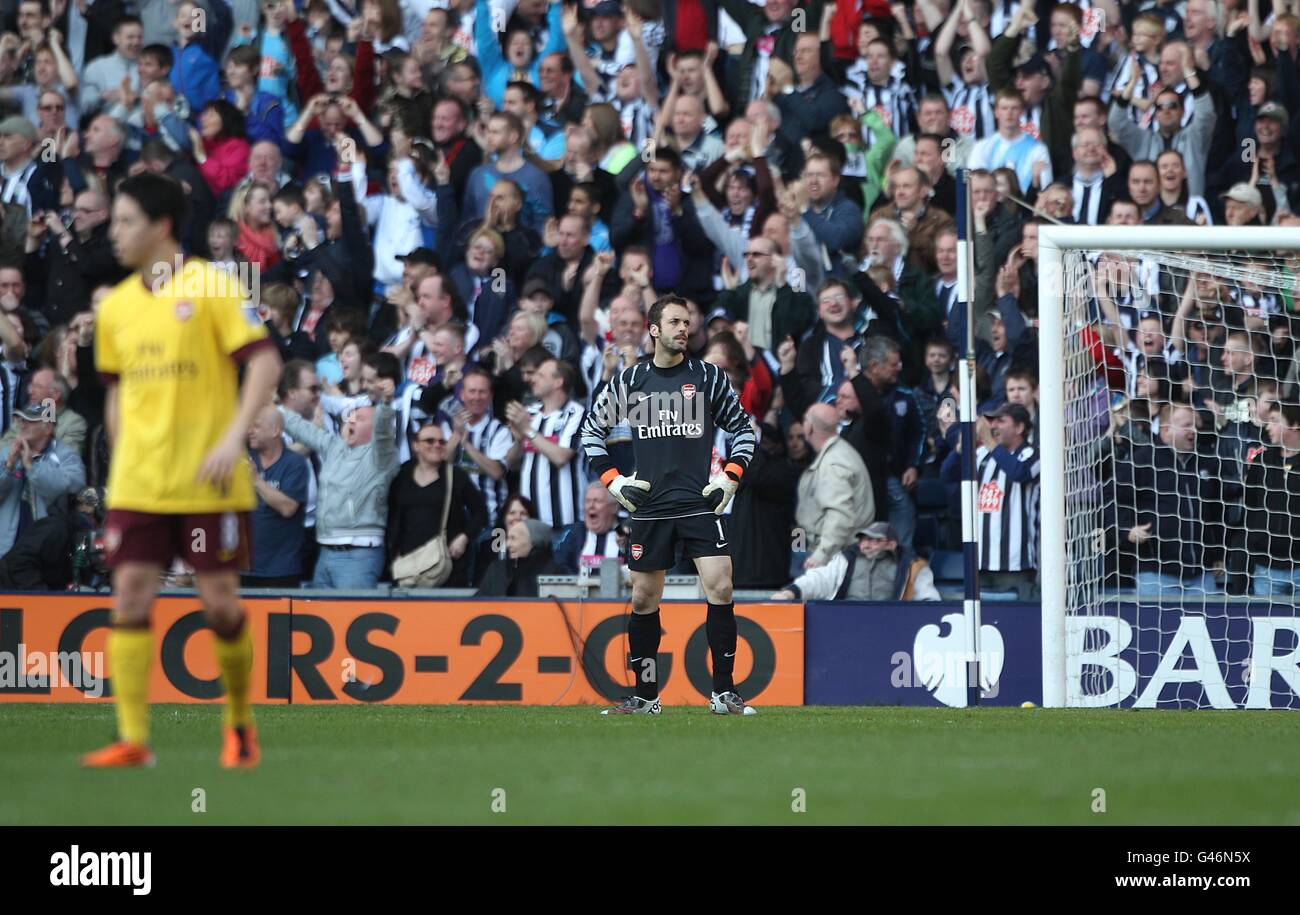 Arsenal goalkeeper Manuel Almunia (centre) stands dejected after West Bromwich Albion's Peter Odemwingie scores their second goal Stock Photo
