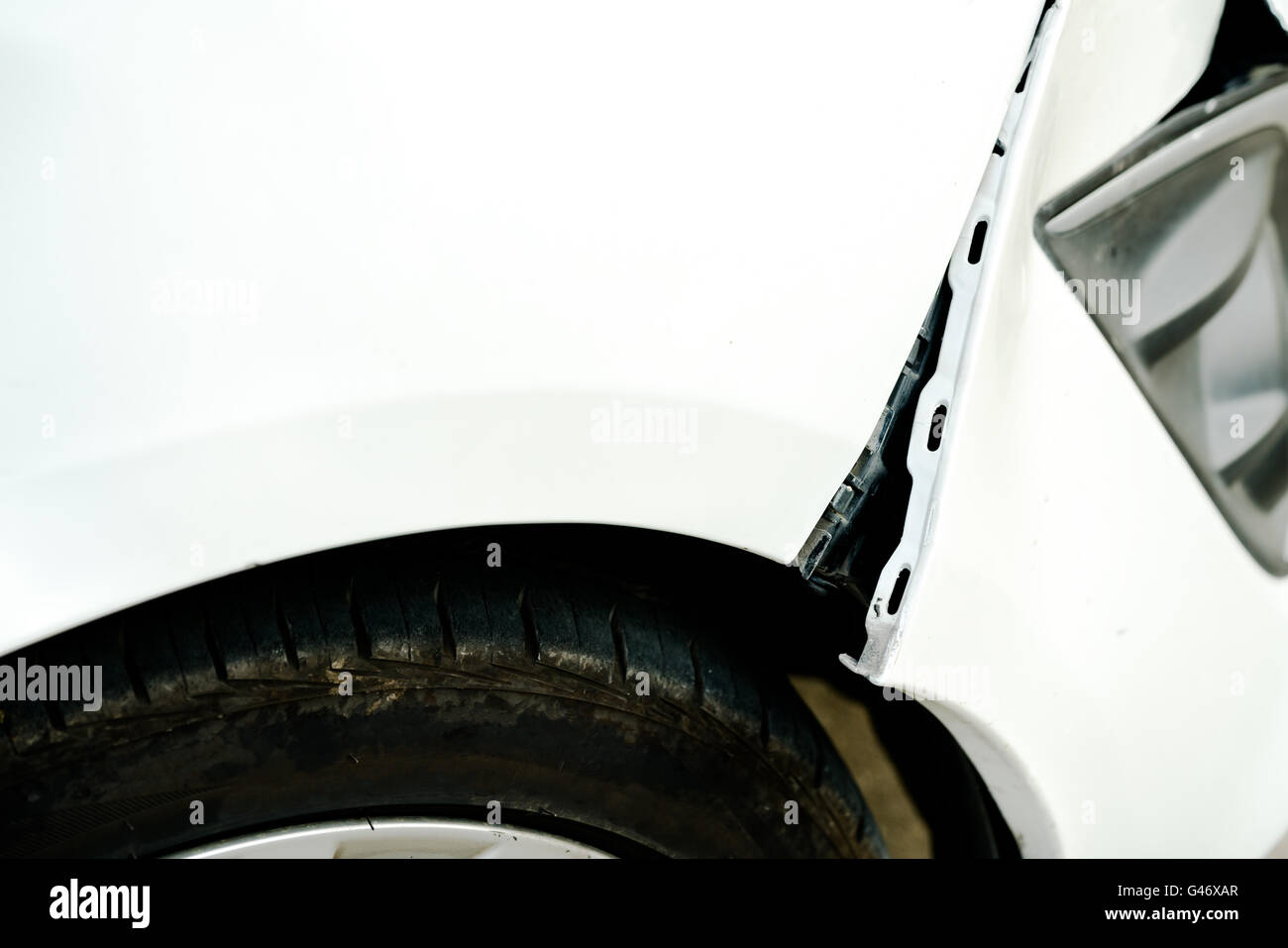 Dented and opening wound on a damaged white car Stock Photo