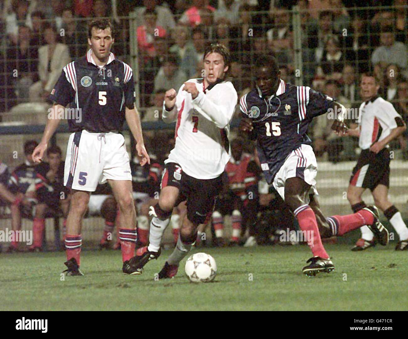 England's David Beckham forces between France's Laure Blanc (left) and Lilian Thuram during the opening minutes of their match in the Tournoi de France at Montpellier, in Southern France today (Saturday) Photo by Sean Dempsey/PA. Stock Photo