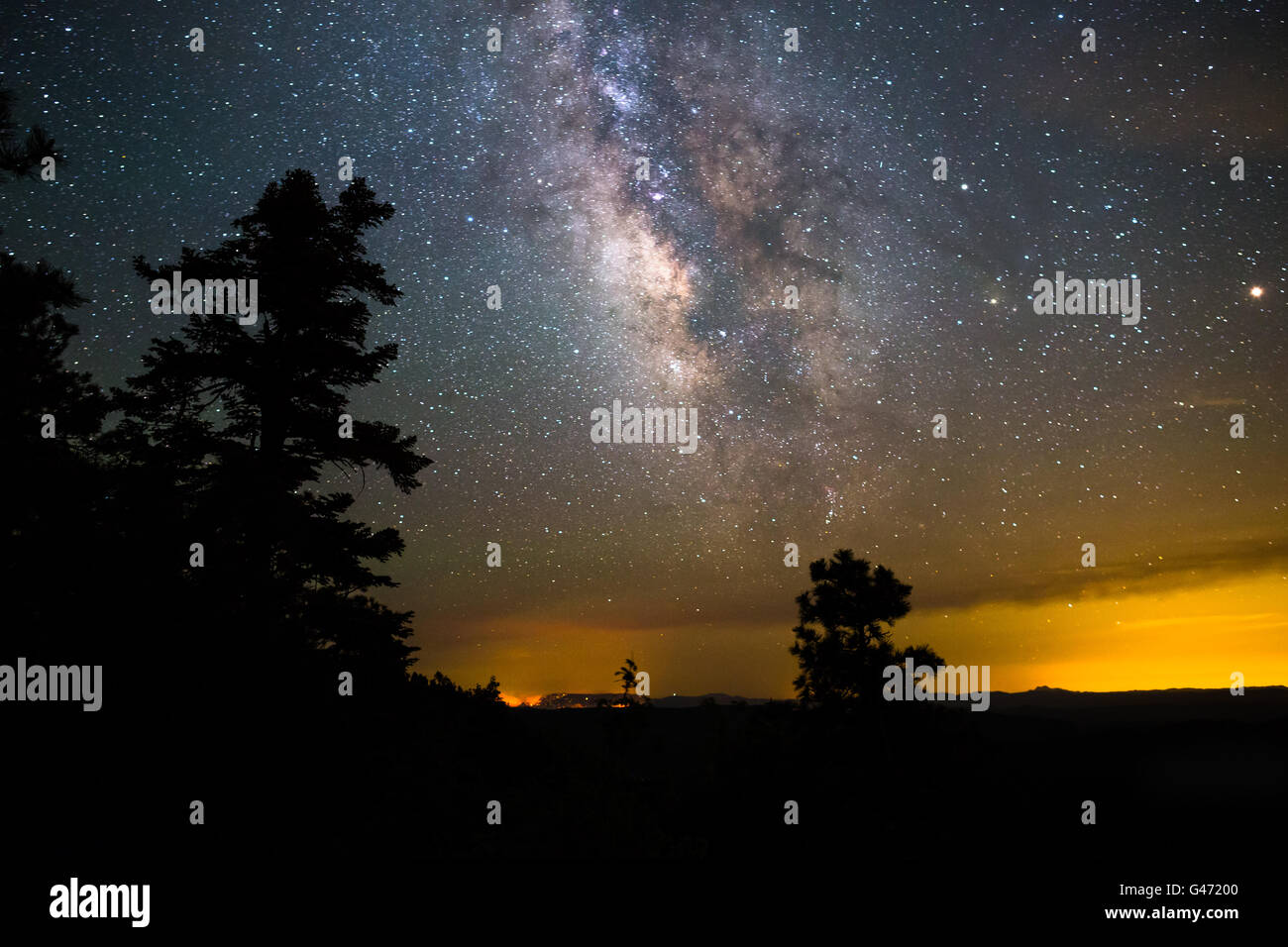 The Milky Way galaxy and night sky above a forest fire near the Mogollon Rim in Arizona Stock Photo