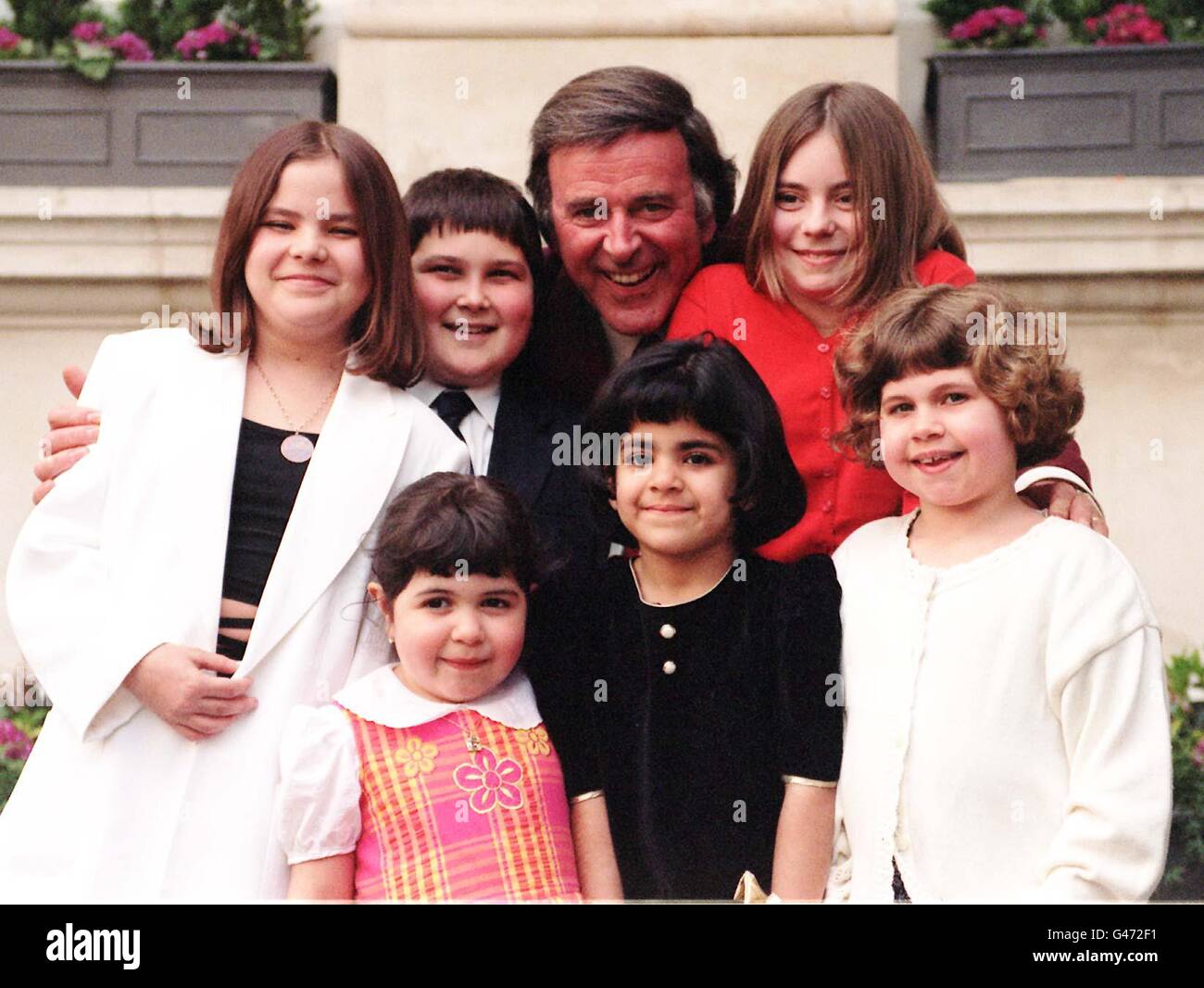 TV and radio presenter Terry Wogan surrounded by children who suffer from arthritis, during today's (Weds) launch of the Charter for children with arthritis in London. (l/r clockwise) Dionne Smith, 13, from Grays in Essex, James Hurson, 12, from Wembley, Danielle Harris, 11, from Surrey, Laura Hillyer, 9, from Burnham, Bucks, Zarfishan Malik, 6, from Dollis Hill and Gabriela Williams, 5, from Hillingdon. Photo by Helen Tilley. See PA Story SHOWBIZ Wogan. Stock Photo