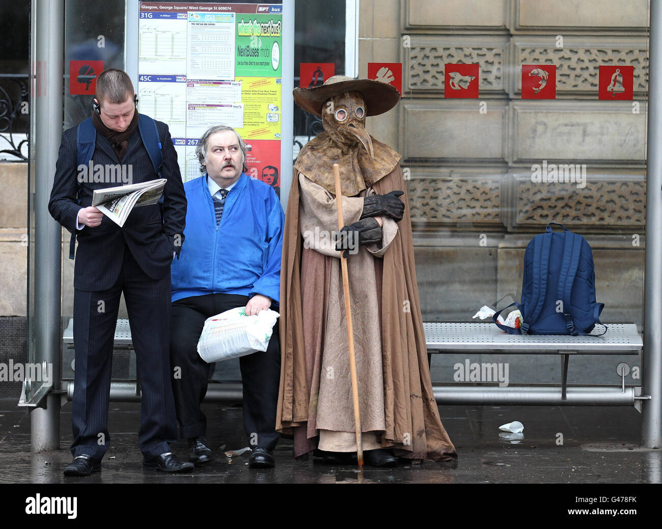 Artist Frank To who is dressed as a medieval plague doctor, stands in a bus shelter during a performance in George Square, Glasgow, as he launches his first exhibition for two years, 'The Human Condition', which will open at Leith Gallery in Edinburgh tomorrow. Stock Photo