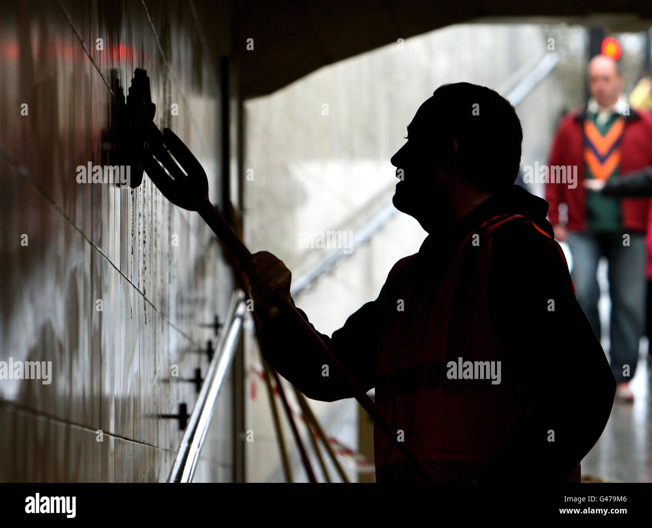 RETRANSMITTED CHANGING CAPTION IN LIGHT OF NEW INFORMATION A convicted offender cleans the wall in the Hyde Park subway, in central London, ahead of the Royal Wedding, as part of a Community Payback scheme managed by Westminster Council and London Probation Trust. Stock Photo