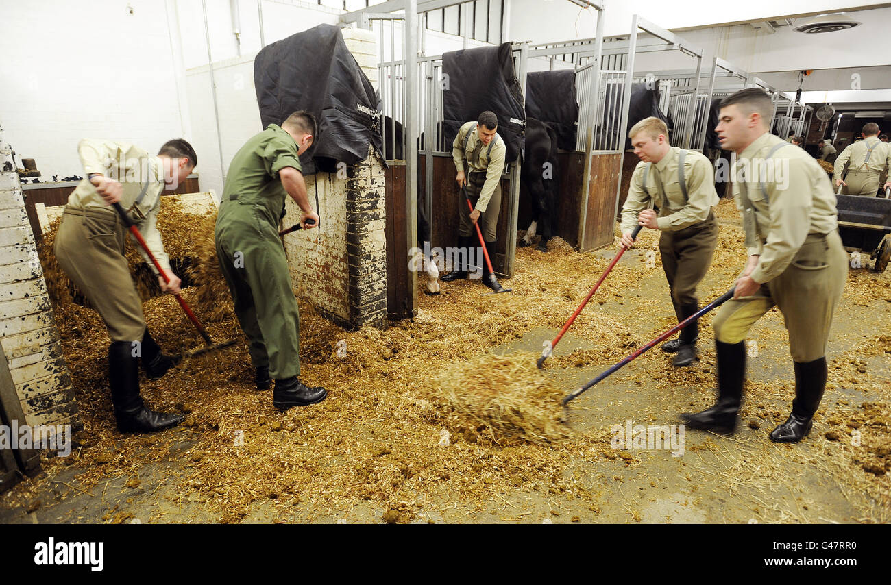 A group of Troopers of the Household Cavalry muck out the stables at