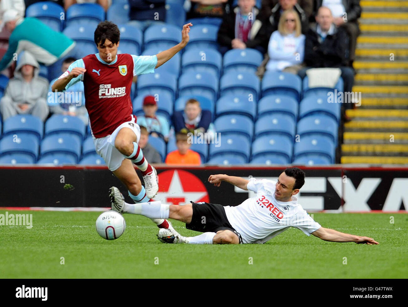 Burnley's Jack Cork (left) battles for the ball with Swansea's Leon Britton during the npower Football League Championship match at Turf Moor, Burnley. Stock Photo