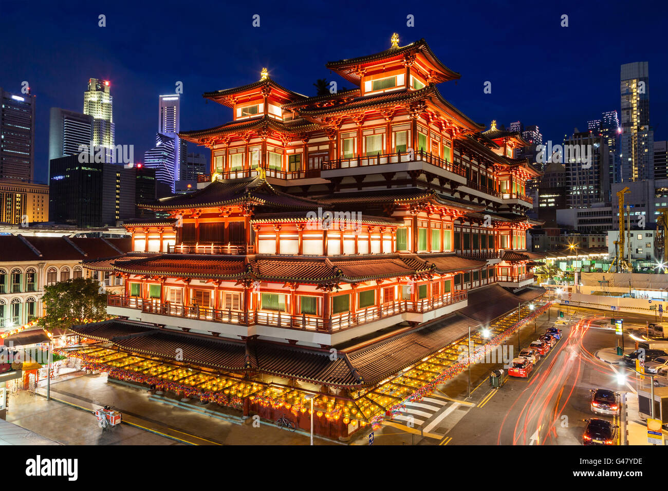 Night view of the Buddha Tooth Relic Temple in Singapore Chinatown, with city skyline in the background. Stock Photo