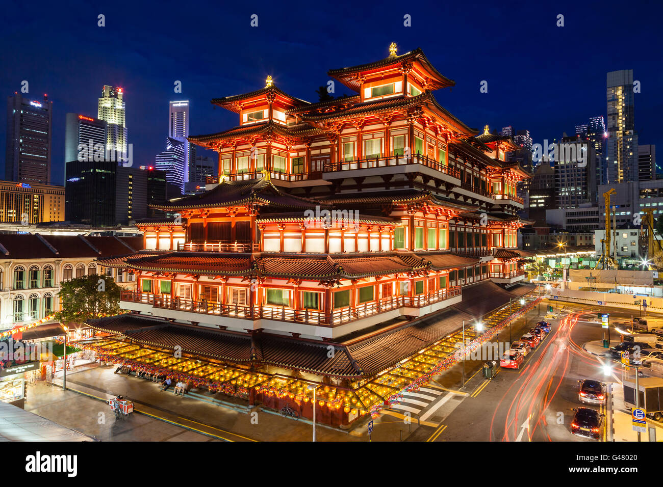 Night view of the Buddha Tooth Relic Temple in Singapore Chinatown, with  city skyline in the background Stock Photo - Alamy
