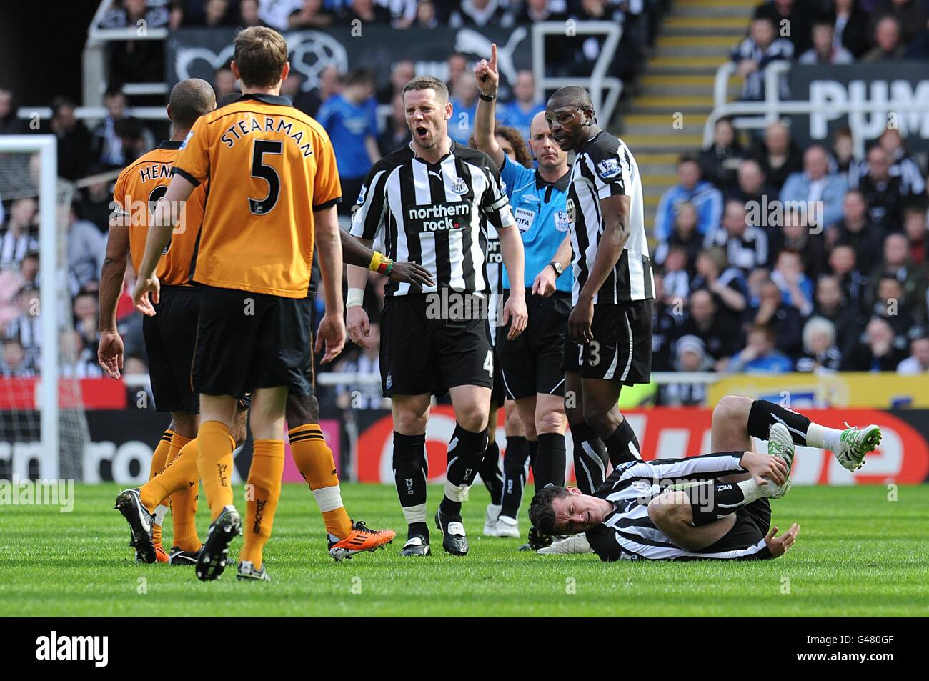 Newcastle United's Kevin Nolan (centre) argues with a group of Wolverhampton Wanderers players whilst his team-mate Joey Barton lies injured on the ground (right) Stock Photo