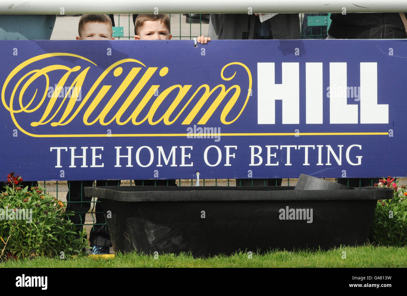 Two young racegoers keep an eye on the parade ring during the William Hill Lincoln Day at Doncaster Racecourse. Stock Photo