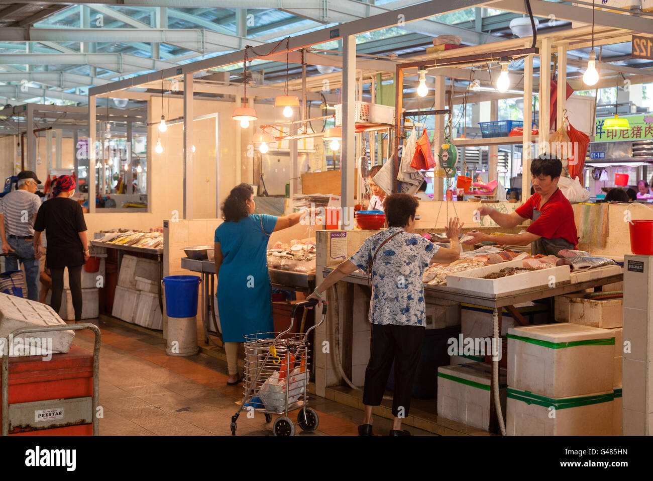 Singapore, Singapore - December 11, 2014: A fishmonger at a local wet market in Singapore helping a customer. For local resident Stock Photo