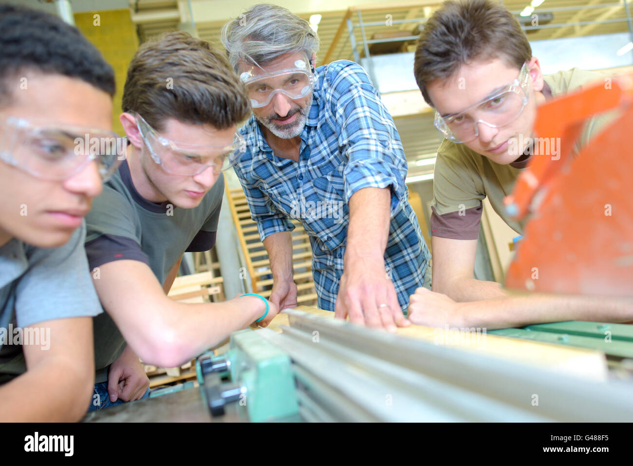 Student Using A Machine Teacher with three students, using machine Stock Photo - Alamy