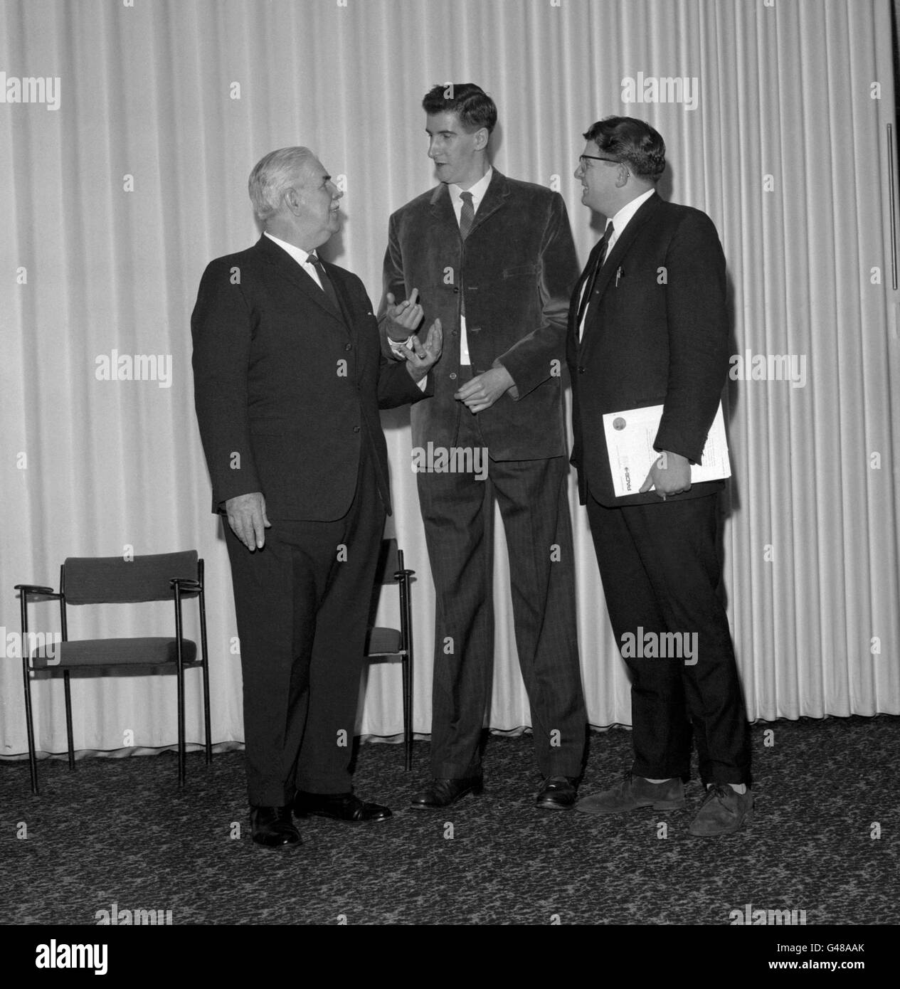 Dennis Concannon, right, the Labour MP for Mansfield, with David Riley of Nottingham, after being measured by ex-Regimental Sergeant Major Ronald Brittain, left, at the Londoner Hotel, London, during the Tallest Man in Town Competition. Stock Photo