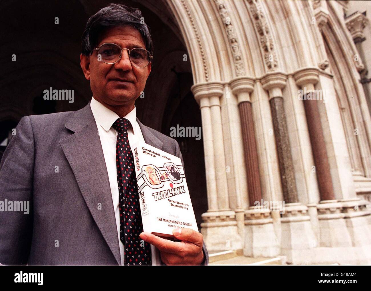 Scientist Dr Harash Narang, holds his book 'The Link', based on on Creutzfeldt-Jakob disease (CJD), outside the Royal Courts of Justice in London, where he is launching an action alleging malicious falsehood against the Public Health Laboratory Service Board and two other named defendants, today (Thursday). Photo by Ben Curtis. See PA Story COURTS Scientist. Stock Photo