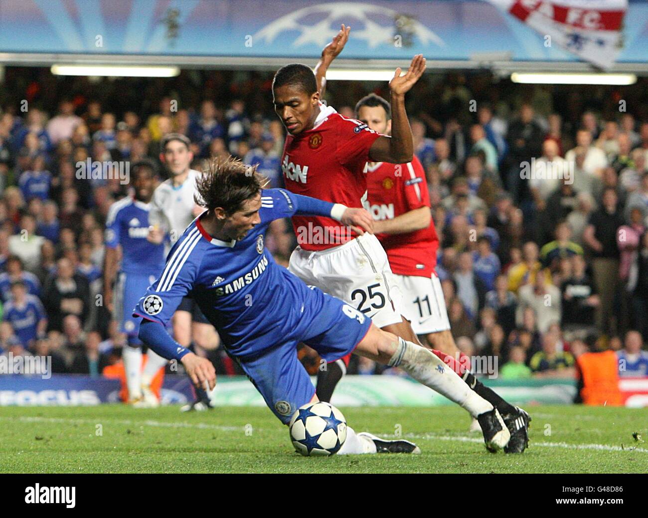 Chelsea's Fernando Torres (left) goes down in the penalty area from a challenge by Manchester United's Antonio Valencia but he is booked by referee Alberto Undiano Mallenco for a dive Stock Photo