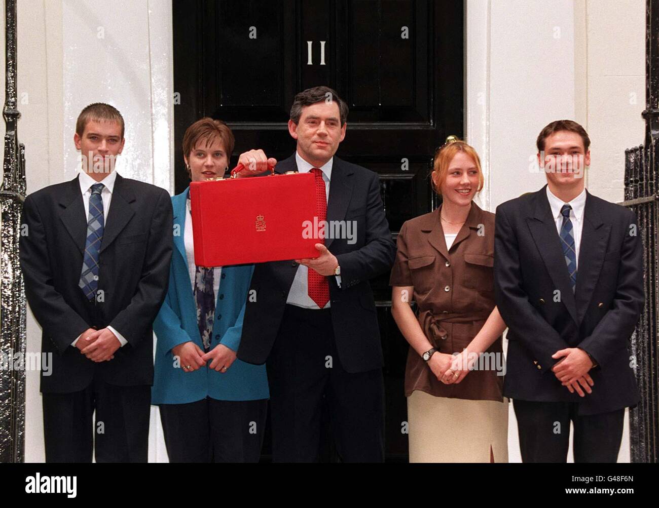 Chancellor Gordon Brown holds aloft the new Budget Box, as he leaves Downing Street today (Wednesday), before he announces the first Labour Budget in 18 years, in the House of Commons. Pictured with the Chancellor are second year apprentices of Babcock Royal Dockyard in Rosyth (l/r) Craig Miller, Leona Reid, Eileen Mallan and Eric Axford, who made the new box. Photo by David Giles. See PA Story COMMONS Budget. Stock Photo
