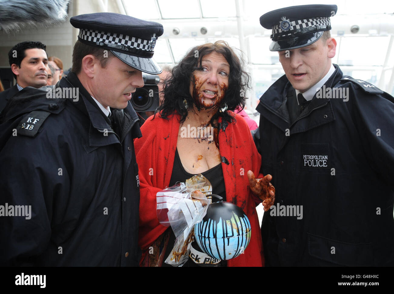 Police talk to shrimp farmer Diane Wilson from Texas who has daubed herself with oil and tried to gain access to the BP AGM in London. Stock Photo