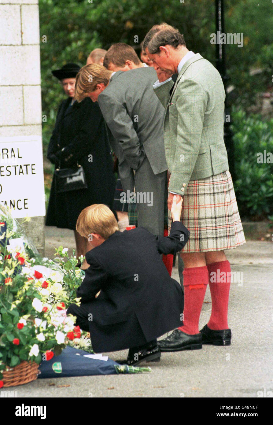 Prince Harry holds onto his father's hand when they stopped outside the gates to Balmoral Castle to look at the floral tributes today (Thursday). Stock Photo