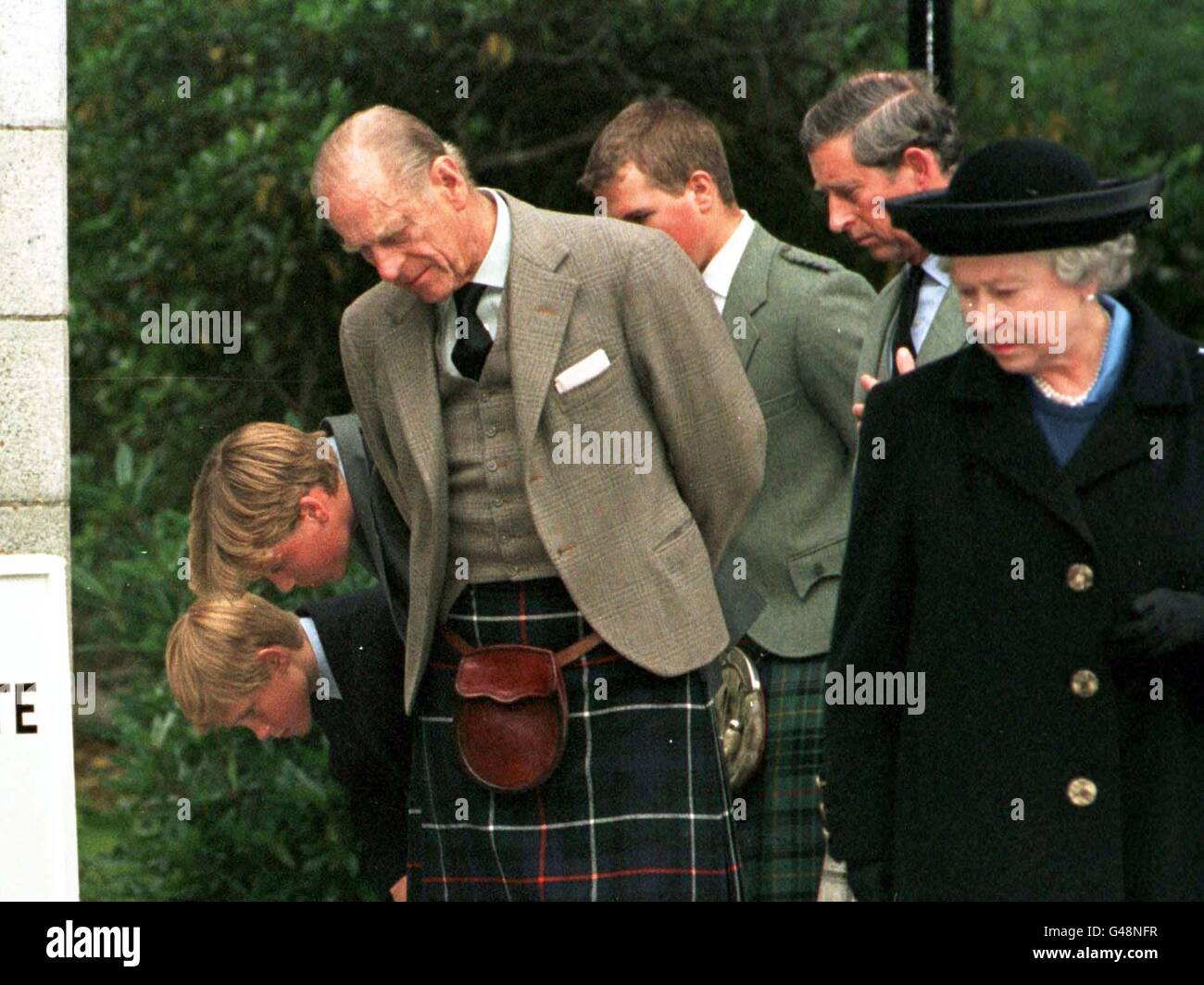Members of the Royal family look at floral tributes outside the gates of Belmoral Castle today (Thursday). Photo by Chris Bacon/PA Stock Photo