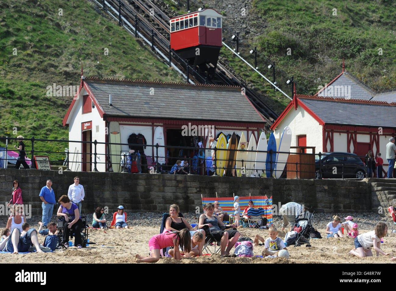 People enjoying the sun on Saltburn-by-the-Sea beach in Cleveland as the warm weather continues in parts of the UK. Stock Photo