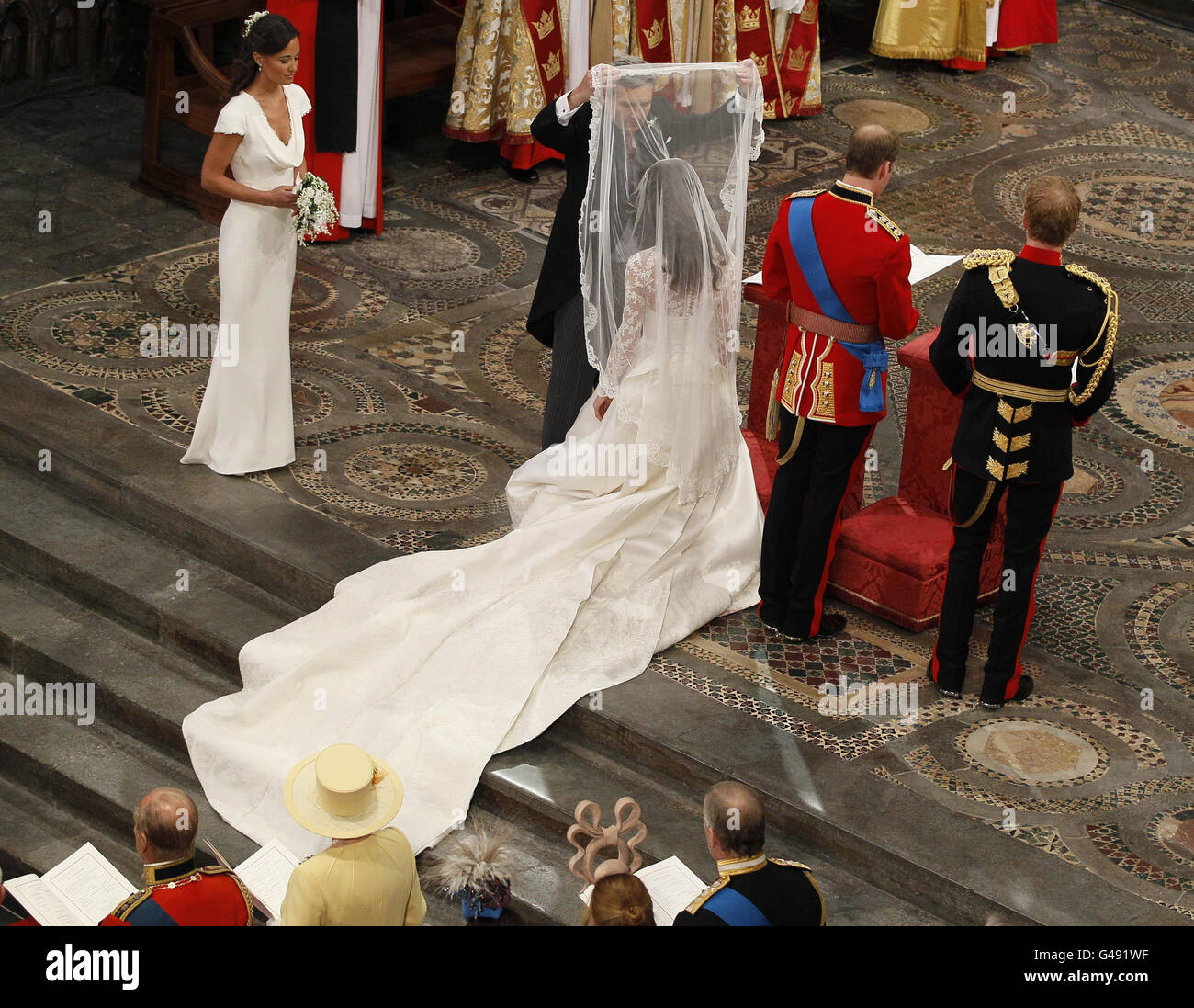 Michael Middleton (second left), Kate Middleton's father, lifts her veil she and Prince William (second right), are by best man Prince Harry, and maid of honour Pippa Middleton, (left),