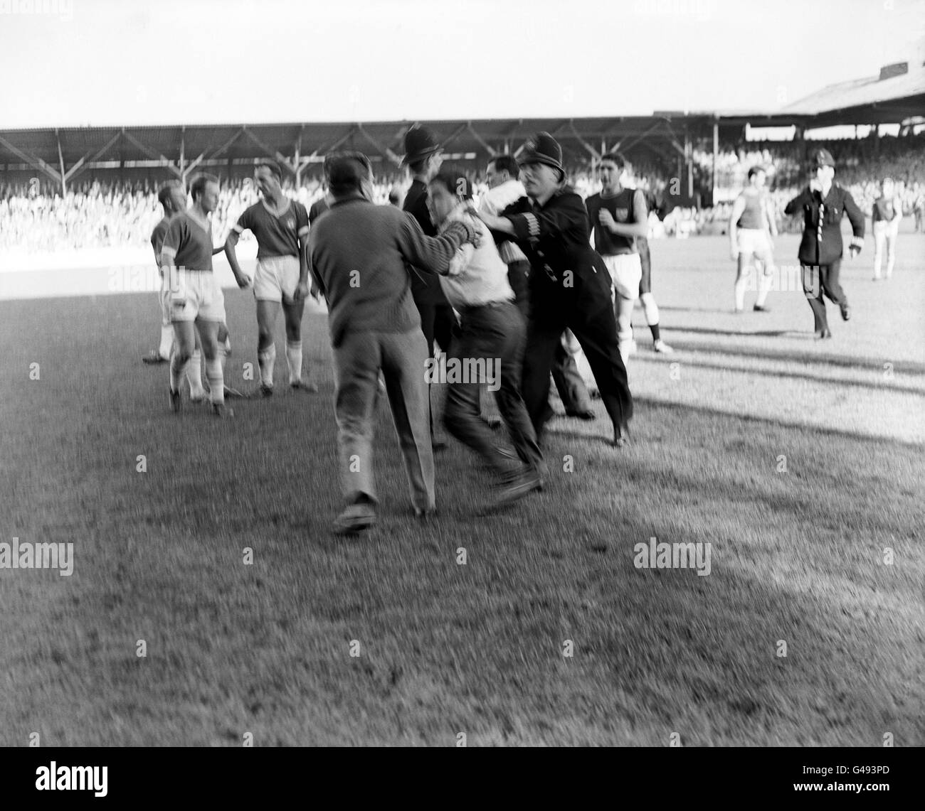 Police move in to remove spectators who had ran on to the pitch and attacked the referee Mr Leslie Hamer following an incident in which West Ham United goalkeeper Lawrence Leslie was carried off on a stretcher. Stock Photo