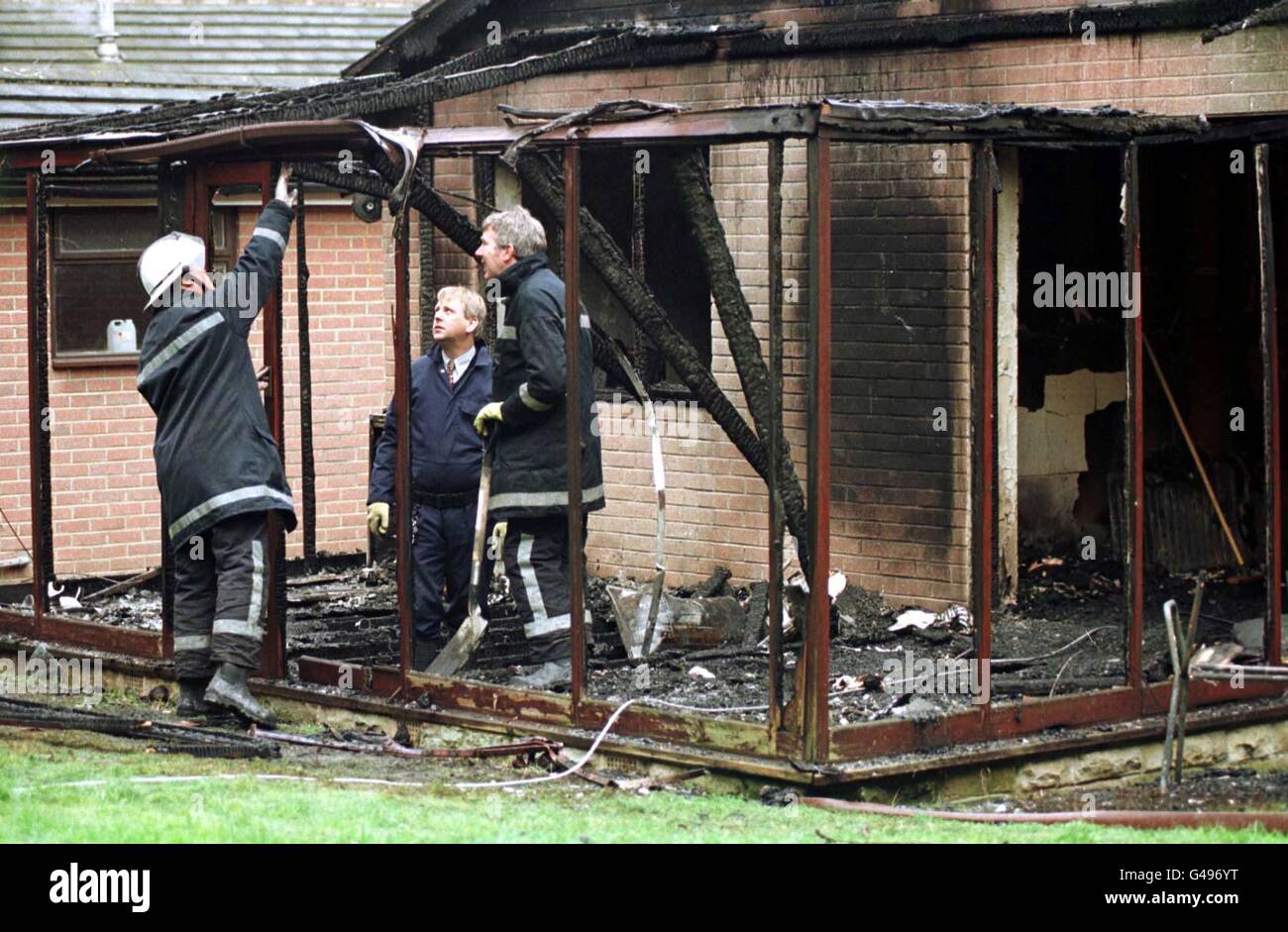 Fire investigation officers examine the charred remains of part of a