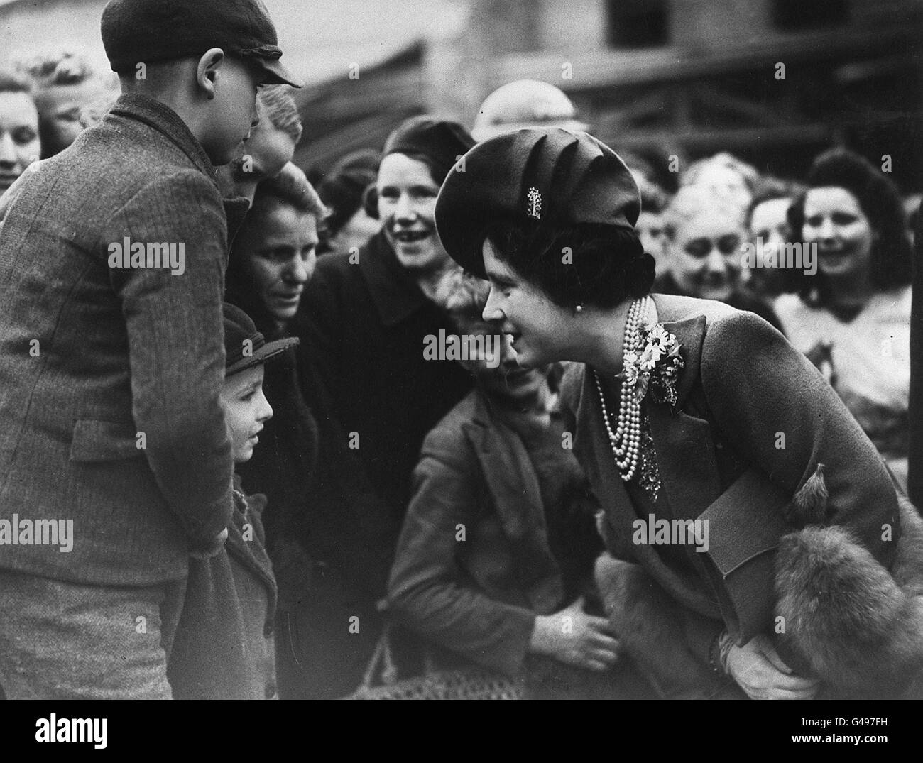 Queen Elizabeth (later the Queen Mother) talk to Michael Webb in the East End of London during her tour of areas damaged by Luftwaffe air raids. Stock Photo