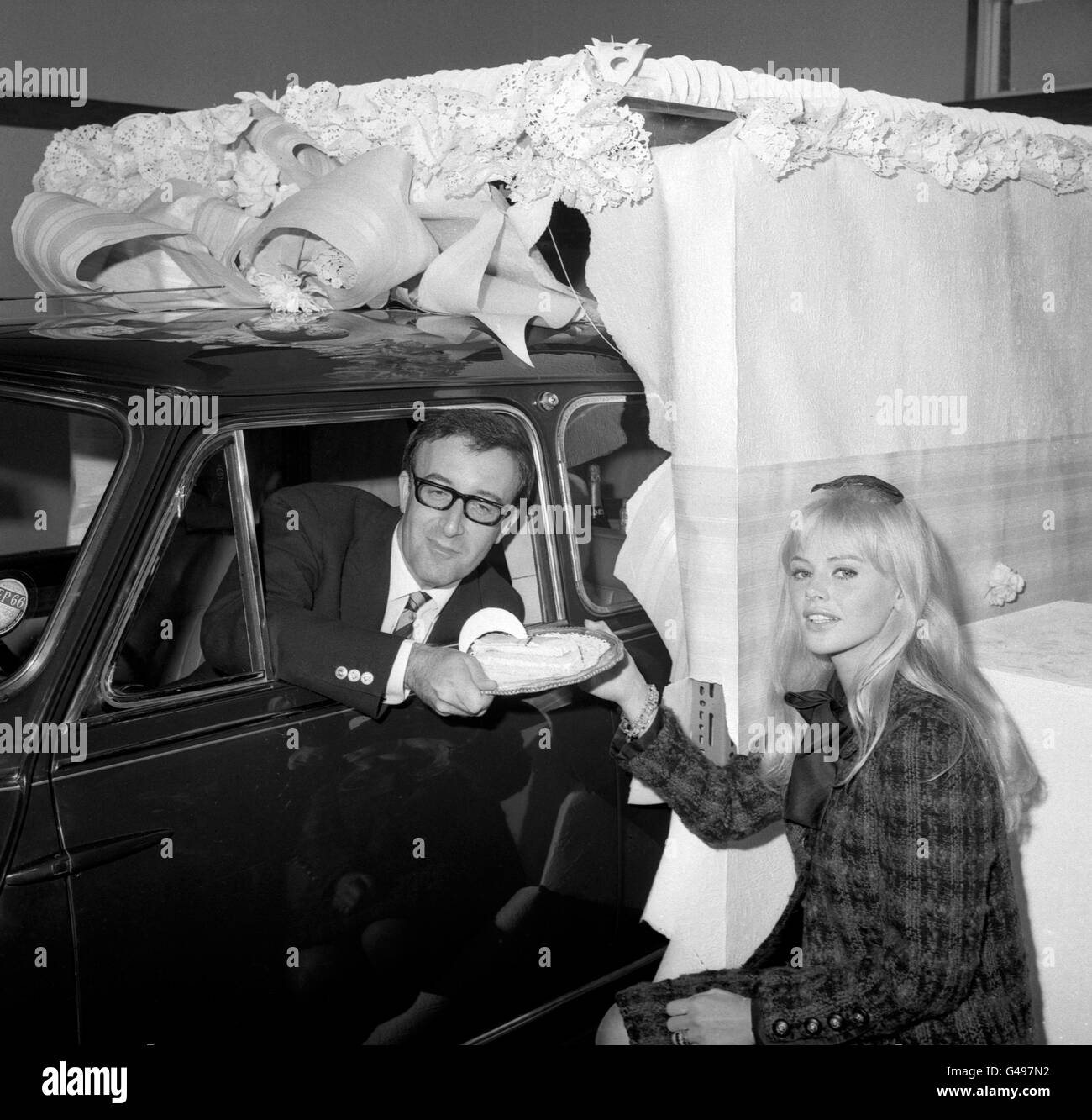 Actor Peter Sellers with his wife Britt Ekland after he had driven a Circassian blue Mini - a birthday present to his wife - through a gigantic cake after officially opening the new showroom for Harold Radford (Coachbuilders) Ltd at Hammersmith, London. Stock Photo