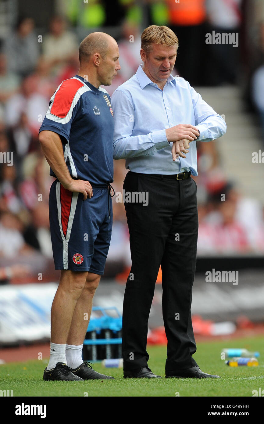 Soccer - npower Football League One - Southampton v Walsall - St Mary's Stadium. Walsall manager Dean Smith (right) looks at his watch on the touchline with his assistant and club physiotherapist Jon Whitney Stock Photo