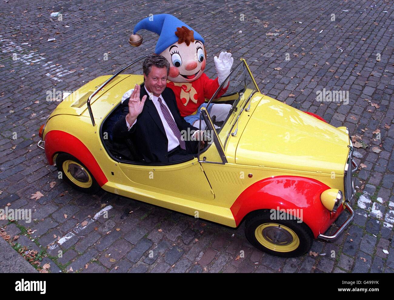 Andrew Teare, chief exec of Rank Group plc takes the driving seat next to Enid Blyton's Noddy, in London today (Weds) , as the company announced their plans to invest 139 million in Butlins, the most famous name in British holidays. As part of the refurbishment programme, there will be a Noddy and Friends in Toy Town play area built, as the three centres in Minehead, Bognor Regis and Skegness close from January 1998, opening in time for the Summer season in April 1998. Photo by Matthew Fearn. Stock Photo