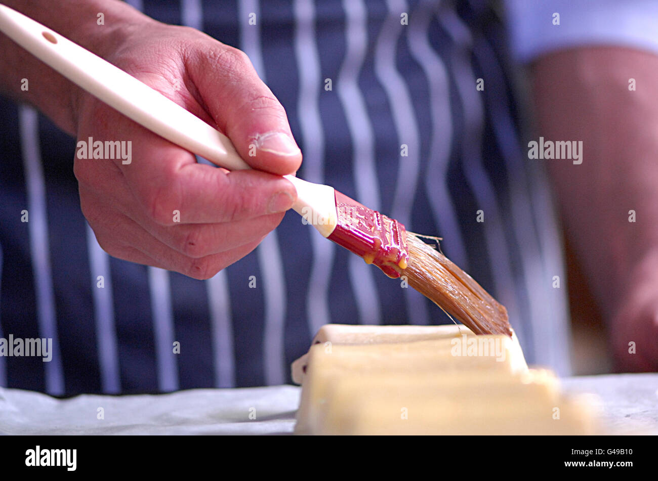 Chef brushing egg onto pastry with pastry brush Stock Photo Alamy