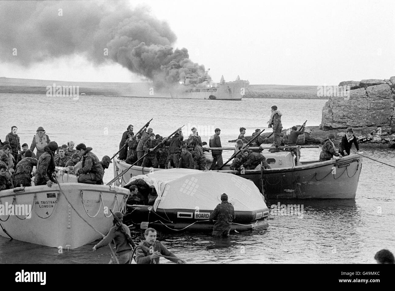 THE FALKLANDS WAR 29/6/82 BLUFF COVE. SURVIVORS COME ASHORE FROM THE BLAZING HMS SIR GALAHAD SHIP AFTER THE DEVASTATING ARGENTINIAN AIR ATTACK AT BLUFF COVE ON THE TWO BRITISH RFA LANDING SHIPS, SIR TRISTRAM AND SIR GALAHAD. *25/03/02 Survivors coming ashore from the Sir Galahad, after it was hit by an Argentinian air attack at Bluff Cove, the Falkland Islands. The 20th anniversary of the invasion of the Falklands by Argentine forces will be on April 2nd, 2002. Stock Photo