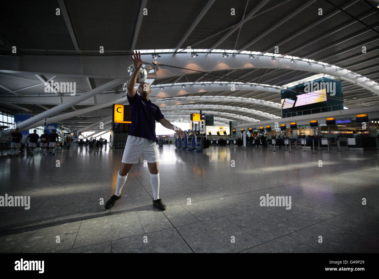 Freestyle footballer Colin Nell demonstrates his skills in Terminal 5 of Heathrow Airport as the UEFA Champions League trophies are displayed ahead of the men's final at Wembley on 28 May 2011 and the Women's Final at Craven Cottage on 26 May 2011. Stock Photo