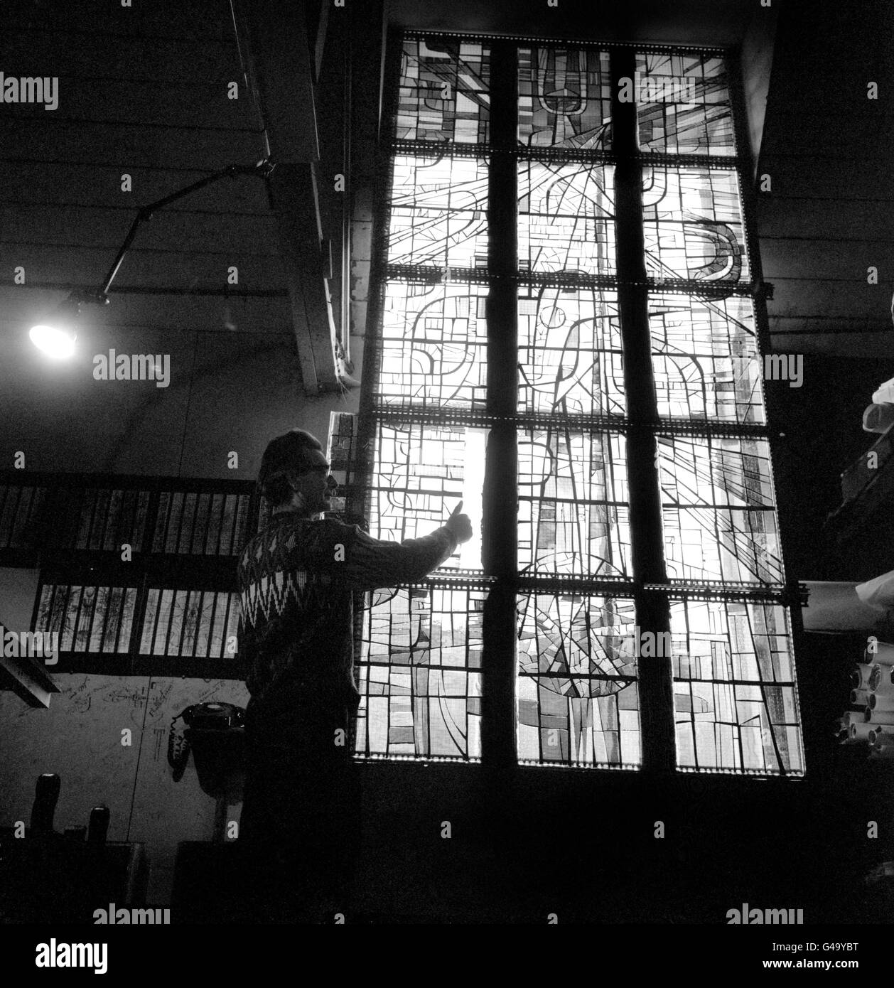 One of the stained glass panels for the Blackburn Cathedral lantern is viewed by the designer John Hayward at his home at Prickloves Farmhouse, Bletchingley, Surrey. The lantern, which will contain almost 1,000 square feet of stained glass based on an abstract theme, will weigh over two tons. and is to be illuminated from the inside and at night will be seen as 'a blaze of colour from all parts of the city'. John Hayward has also designed a 30ft steel figure of CHrist, already installed at the Cathedral, and a huge steel corona, weighing four tons, to be suspended over the High Altar. Stock Photo