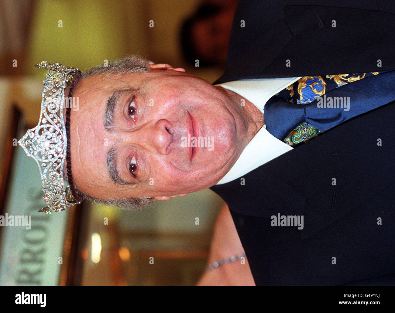 Harrods proprietor Mohammed Al Fayed, (D.O.B. 27/01/33) wearing a Kojis 136 carat diamond and platinum coronet, which has been reduced from 250,000 to 187, 500 (a reduction of 25%), in the Harrod's sale which opened today (Weds), despite the last minute cancellation of its celebrity guest. Superstar Cher pulled out of the opening of the prestigious store's sale after hearing that her ex-husband and pop partner Sonny Bono had been killed in a mystery skiing accident.. See PA Story CONSUMER Harrods. Photo by Fiona Hanson. Stock Photo